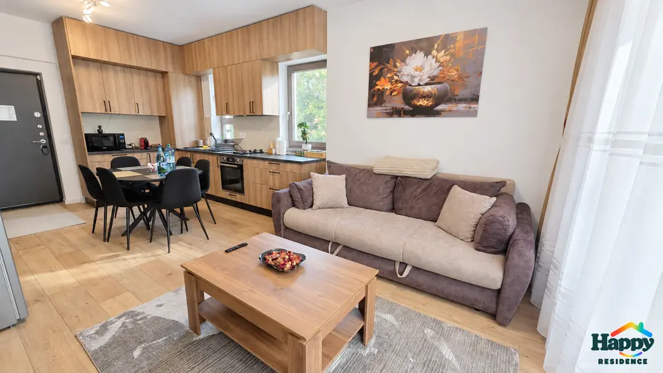 Living luminos cu bucătărie deschisă, masă și canapea extensibilă – Happy Residence Craiova